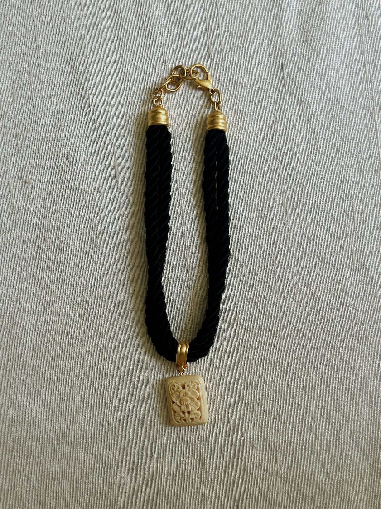 Black Rope Necklace with Carved Ivory Tone Pendant